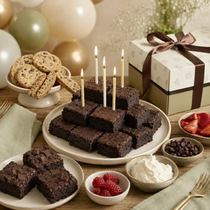 Ruth’s extra-fudgy brownies arranged as a birthday tower with cream candles and branded gift packaging