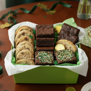 Assorted cookies including brownies and cookies in a green box on a wooden table st paddys day gift basket.