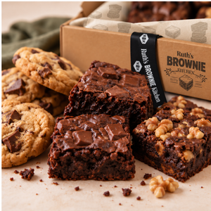 Close-up of Ruth's gluten-free original, chocolate chunk and walnut brownies with a chocolate chunk cookie and brownie-print tissue paper
